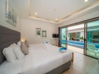 a bedroom with a large white bed and a pool at 2Exclusive 4BR Villa with Private Pool Kitchen Ideal for Families in Ban Bang La