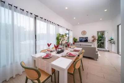 a dining room with a white table and chairs at 3Elegant 4BR Villa with Pool in Ban Bang La