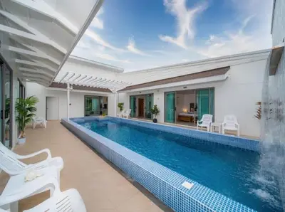 a swimming pool with white chairs and a house at 3Elegant 4BR Villa with Pool in Ban Bang La