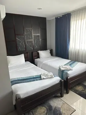 a hotel room with two beds and a window at Sparta beachfront patong in Patong Beach