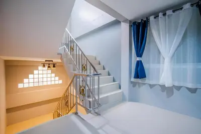 a staircase in a house with a blue curtain at Sparta beachfront patong in Patong Beach