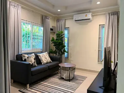 a living room with a couch and a television at Home Tambon Bang tao 2BR Near Beach in Surin Beach