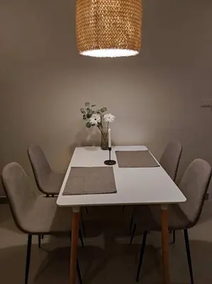 a white table with chairs and a vase with flowers on it at Home Tambon Bang tao 2BR Near Beach in Surin Beach