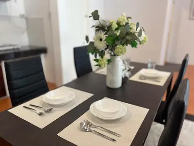 a dining room table with a vase of flowers on it at Prime Hill Kathu Phuket D3 in Ban Ket Ho
