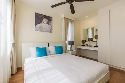 a bedroom with a white bed with blue pillows at Laguna Park Townhouse by Villacarte in Laguna Phuket