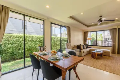 a living room with a wooden table and chairs at Laguna Park Townhouse by Villacarte in Laguna Phuket