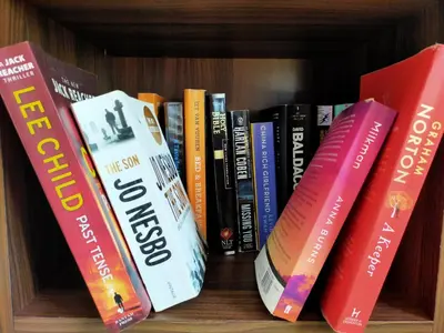 a row of books sitting on a book shelf at Orchidilla Residence Phuket Mai Khao Beach - SHAPlus in Mai Khao Beach