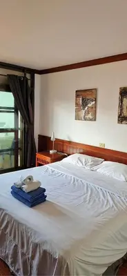 a bedroom with a white bed with towels on it at The little Mermaid in Patong Beach
