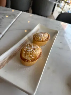 two donuts sitting on a plate on a table at The little Mermaid in Patong Beach