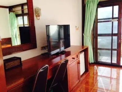 a living room with a tv and a wooden desk at The little Mermaid in Patong Beach