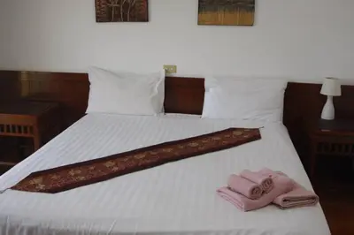 a bed with two towels and two slippers on it at The little Mermaid in Patong Beach