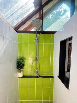 a bathroom with a shower with green tiles at Green Haven Villas in Krabi town