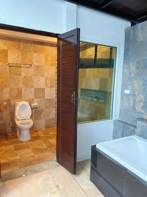 a bathroom with a shower and a toilet and a tub at Green Haven Villas in Krabi town