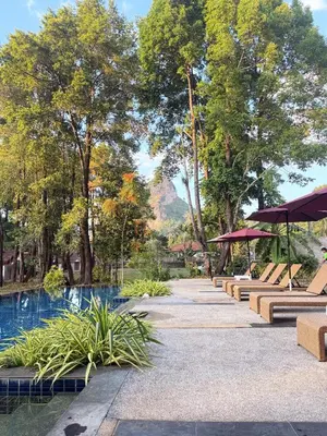 a park with a pool and benches and trees at Green Haven Villas in Krabi town
