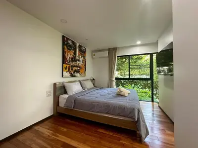 a bedroom with a large bed and a large window at Apartment Title III Rawai Phuket in Rawai Beach