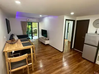 a kitchen and living room with a table and a refrigerator at Apartment Title III Rawai Phuket in Rawai Beach