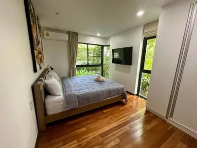 a bedroom with a bed and a large window at Apartment Title III Rawai Phuket in Rawai Beach