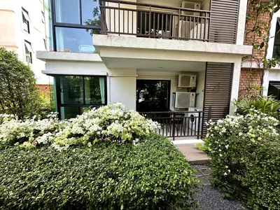 a house with a balcony and flowers in front of it at Apartment Title III Rawai Phuket in Rawai Beach