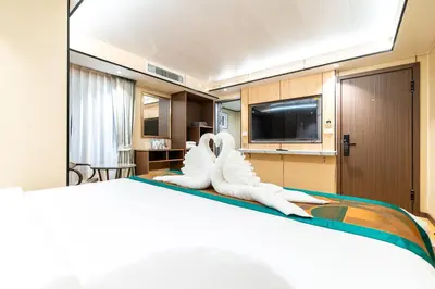a hotel room with a bed with white boots on it at Phuket Patong Buri Resort in Patong Beach