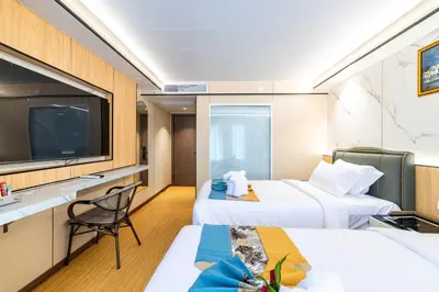 a hotel room with two beds and a flat screen tv at Phuket Patong Buri Resort in Patong Beach