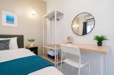 a bedroom with a bed and a desk with a mirror at 6BR Patong pool villa in Patong Beach