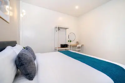 a white bedroom with a large bed and a mirror at 6BR Patong pool villa in Patong Beach
