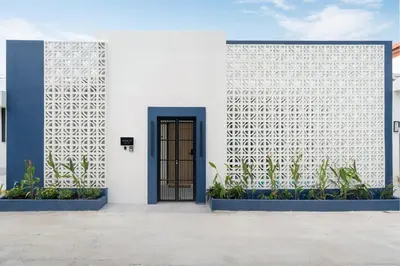 a white building with a blue door and plants at 6BR Patong pool villa in Patong Beach