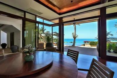 a dining room with a table with a view of the ocean at Villa Daran Luxury Villa with Panoramic Views & 5-Star Services in Kamala Beach