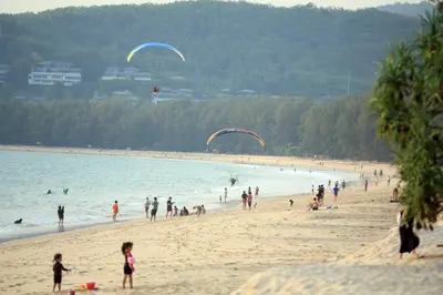 a group of people on a beach flying kites at 1bdr New Apartment near Layan Beach in Ko Kala