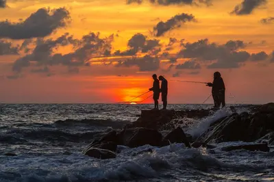 three people fishing on the beach at sunset at 1bdr New Apartment near Layan Beach in Ko Kala