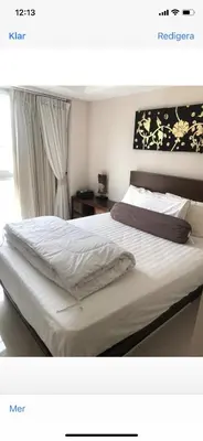 a bedroom with a large bed with white sheets at Cristians lägenhet in Kata Beach