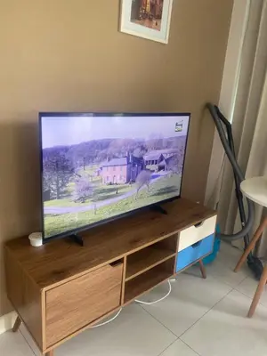 a flat screen tv sitting on top of a wooden entertainment center at Cristians lägenhet in Kata Beach