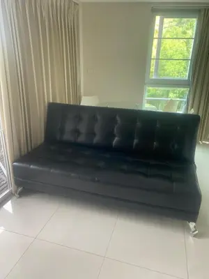 a black leather couch in a room with a window at Cristians lägenhet in Kata Beach