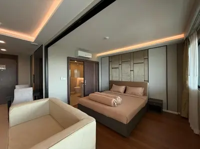 a bedroom with a bed and a couch at Surin Mida Grande residence with jacuzzi and sea view - Bang Tao & Surin beach in Surin Beach