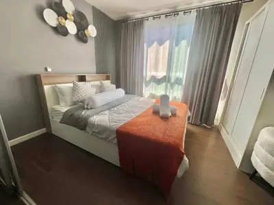 a bedroom with a bed with a table and a window at Dcreek 79 Modern chic condo near patong in Phuket Town