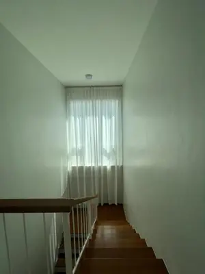 a stairway with a white curtain and a window at Supicha86 Sino ko kaeo Modern Private 3BR 3BA Villa in Ban Bang Khu