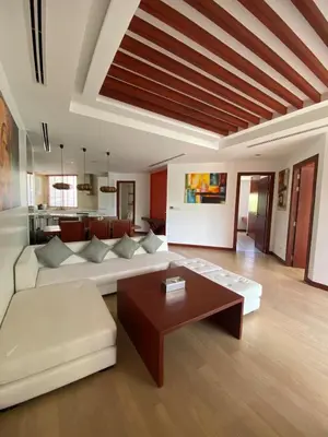 a living room with a white couch and a table at Beachfront in Surin Beach