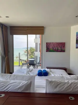 a bedroom with two beds and a view of the ocean at Beachfront in Surin Beach