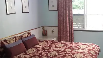 a bedroom with a bed and a window at Nan Inn Bungalow in Karon Beach