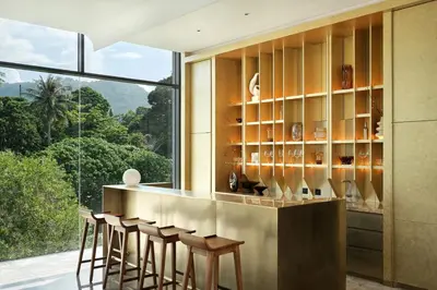 a bar with stools in a room with a large window at Villa Zai in Kata Beach