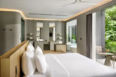 a bedroom with a white bed and a bathroom at Villa Zai in Kata Beach