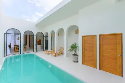 a swimming pool in a house with wooden doors at Balina Private Pool Villa in Ban Chin Tham Mai