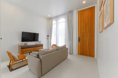 a living room with a couch and a television at Balina Private Pool Villa in Ban Chin Tham Mai