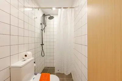 a white bathroom with a shower and a toilet at Fantasea Kamala Walk to Beach Pool & Gym Modern 1BR in Kamala Beach