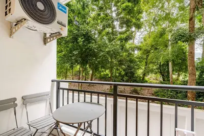 a balcony with a speaker and a table and a chair at Fantasea Kamala Walk to Beach Pool & Gym Modern 1BR in Kamala Beach