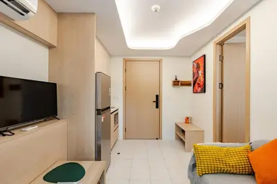 a living room with a couch and a flat screen tv at Fantasea Kamala Walk to Beach Pool & Gym Modern 1BR in Kamala Beach