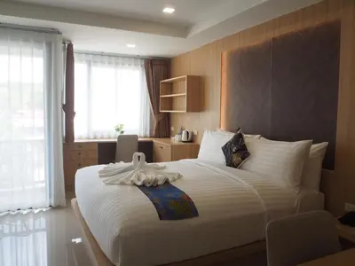 a bedroom with a large bed with a large white bedspread at The Village Poshtel in Ban Khlong Haeng