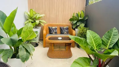 a room with a chair and a table and plants at The Village Poshtel in Ban Khlong Haeng