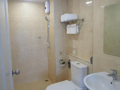 a bathroom with a shower and a toilet and a sink at The Village Poshtel in Ban Khlong Haeng