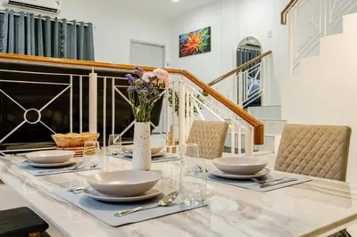a dining room table with a vase of flowers on it at 2 bed townhouse, best location, Patong in Patong Beach